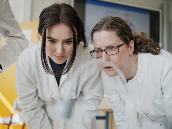 student and teacher looking at a chemical experiment