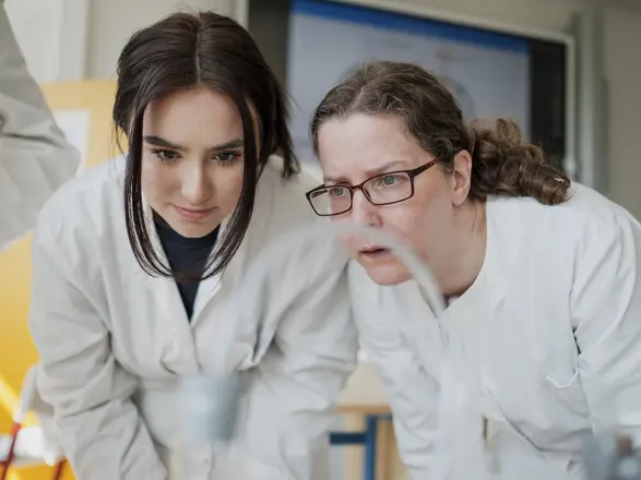 student and teacher looking at a chemical experiment