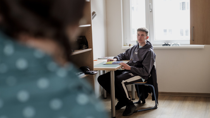 Boarding school student sitting in his room