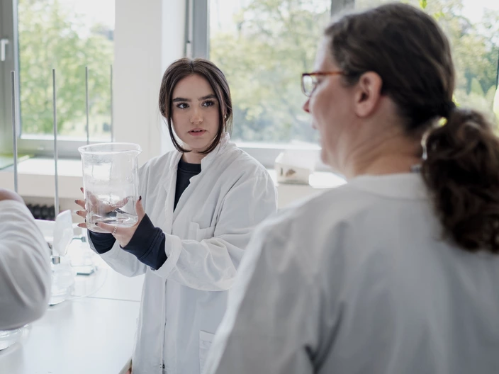 student and teacher talking about a chemical experiment